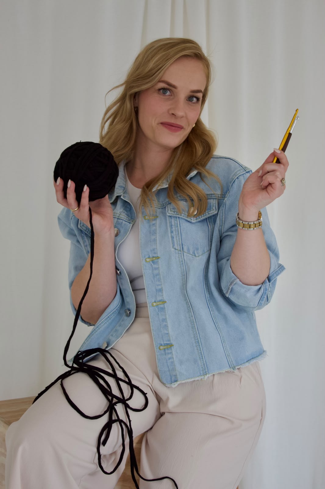 The maker behind El-Za, crochet hook and yarn in hand